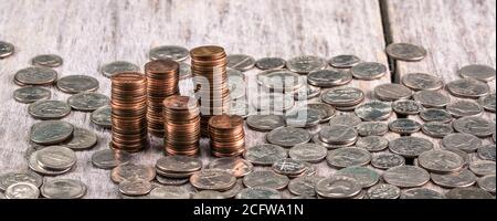 Piles de vieux pennies sur une table en bois entre autres pièces Banque D'Images