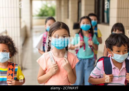 les enfants portant un masque médical pour le visage de retour à l'école après le covid-19 quarantaine Banque D'Images