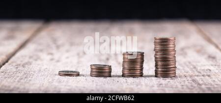 Piles de quartiers sur une ancienne table en bois / investissement concept de croissance Banque D'Images