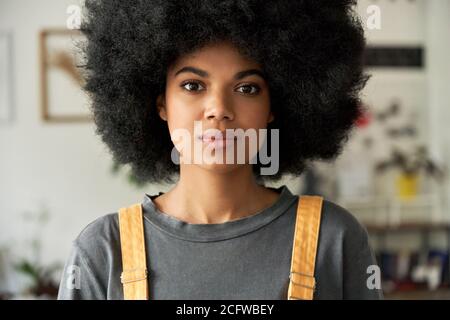 Femme africaine confiante avec cheveux afro regarde l'appareil photo, portrait de tête. Banque D'Images