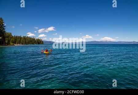 Deux kayakistes qui profitent d'une journée ensoleillée sur le lac Tahoe au parc national de Sugarpine, de belles nuances de bleu à vert, de légères ondulations de vent, de bateaux, Banque D'Images