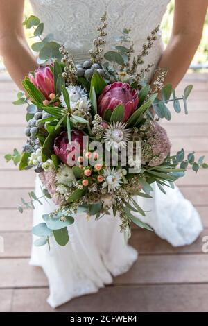 Mariée tenant un bouquet de fleurs indigènes australiennes Banque D'Images