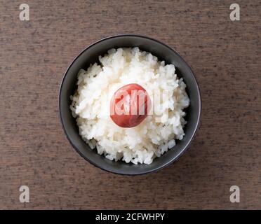 Vue panoramique sur les prunes japonaises marinées et fraîchement cuites riz sur fond de bois Banque D'Images