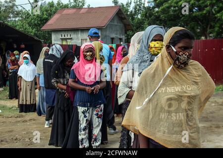 Lhokseumawe, Indonésie. 07septembre 2020. Les Rohingya font la queue en portant un masque facial pour subir des contrôles médicaux et des tests rapides dans un refuge temporaire à Lhokseumawe.près de 300 musulmans Rohingya ethniques ont été bloqués dans les eaux de la mer d'Aceh, composé d'adultes et d'enfants faibles en raison de la déshydratation et de la faim après avoir été influencés en haute mer. Crédit : SOPA Images Limited/Alamy Live News Banque D'Images