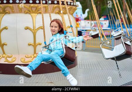 une jeune fille drôle roule sur un carrousel Banque D'Images