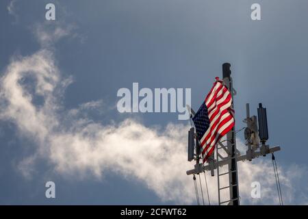 Le pont d'un grand navire dans l'océan Avec des tours de cellules Etats-Unis d'Amérique drapeau soufflant dans Le vent Banque D'Images