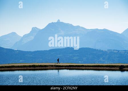 Silhouette de la promenade touristique non reconnaissable seule près du lac dans le col de montagne de Joux plane. Alpes françaises dans la région de Morzine, haute-Savoie, Banque D'Images