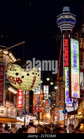 Une grande lanterne de poisson à l'extérieur du restaurant Zuboraya avec la tour Tsutenkaku derrière, dans le quartier Shinsekai d'Osaka. Japon Banque D'Images