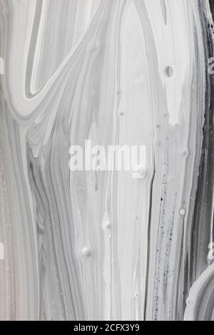 Fond d'encre des ondulations verticales monochromes. Texture gris-blanc imitant le marbre Banque D'Images