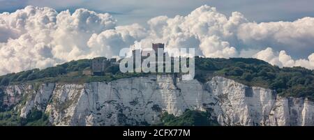 Vue panoramique des falaises blanches de Douvres et d'un château au sommet de la falaise. De beaux nuages moelleux en arrière-plan. Banque D'Images