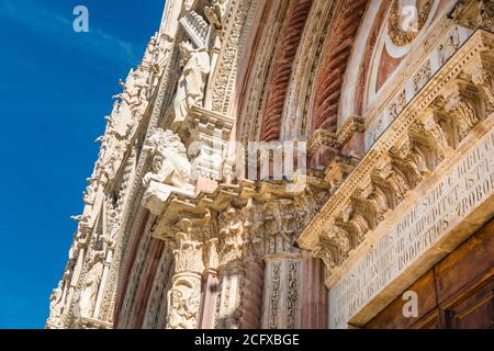 Belle vue rapprochée d'un portail sur la façade ouest de la cathédrale de Sienne en Italie. Le portail, surmonté d'une lunette, ainsi que les zones autour... Banque D'Images
