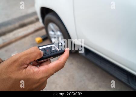 Appuyez à la main sur le bouton de la télécommande pour verrouiller ou déverrouiller la voiture à l'aide de la télécommande. Banque D'Images