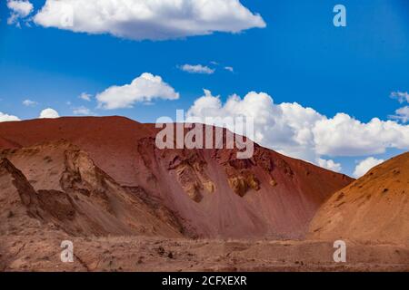 Carrière de minerai d'aluminium. Bauxite à ciel ouvert (coupe ouverte) pour l'exploitation minière. De grosses tas jaunes de roches vides. Ciel bleu avec nuages. Banque D'Images