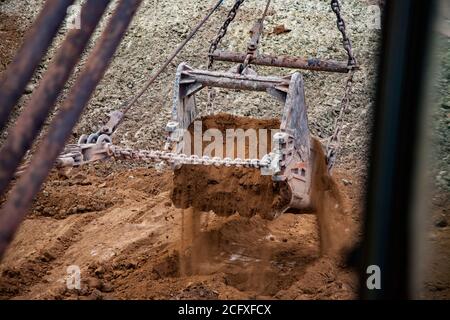 Carrière de minerai d'aluminium. Mine de bauxite à coupe ouverte. Pelle à benne traînante. Godet avec sol vide (roches vides). Banque D'Images