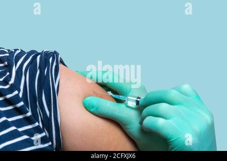 L'infirmière tenant la seringue injecte le patient. Le médecin fait la vaccination à la femme. Vaccination à l'épaule. Concept de santé et de médecine Banque D'Images