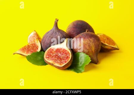 Fruits frais de figue et tranches sur fond jaune Banque D'Images