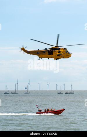 Un hélicoptère de sauvetage et un canot de sauvetage en action en mer. Banque D'Images