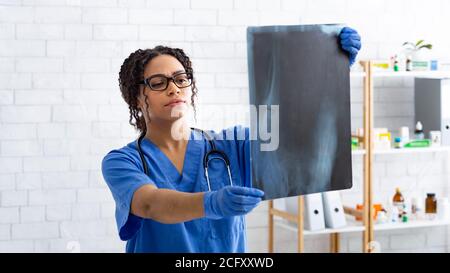 Médecin vétérinaire noir sérieux étudiant la radiographie animale au bureau médical Banque D'Images