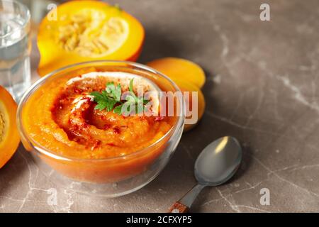 Composition avec bol de soupe de citrouille sur fond gris, espace pour le texte Banque D'Images