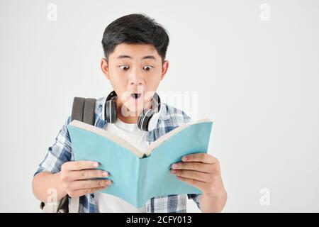 Un écolier choqué lisant un livre Banque D'Images