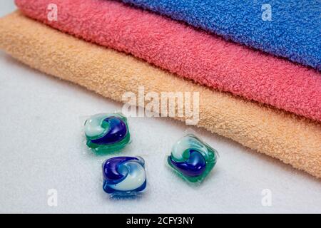 Dosettes de lessive pour lave-linge et serviettes de bain colorées. Capsule de gel écologique trois en une. Banque D'Images