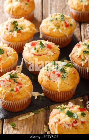 Des muffins au maïs avec de la viande de crabe et du fromage en gros plan sur une plaque d'ardoise sur la table. Vertical Banque D'Images