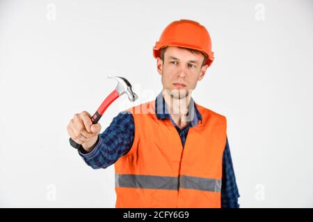 Guy knoking métal brillant marteau maître de réparation porter casque uniforme, concept d'outils professionnels. Banque D'Images