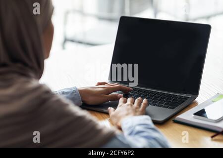 Femme dans hijab utilisant un ordinateur portable avec écran vide Banque D'Images