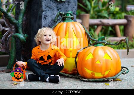 Enfant en costume d'Halloween. Les enfants font des trucs ou des friandises. Petit garçon habillé avec lanterne de citrouille. Célébration familiale. Banque D'Images