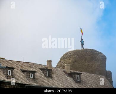 Homme debout sur le grand rocher depuis le sommet de l'OMU et prise de photos Banque D'Images