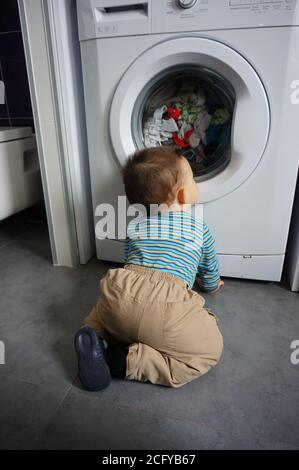 POZNAN, POLOGNE - 18 avril 2015 : petit garçon devant une machine à laver Banque D'Images