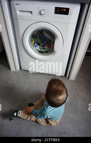 POZNAN, POLOGNE - 18 avril 2015 : petit garçon devant une machine à laver Banque D'Images