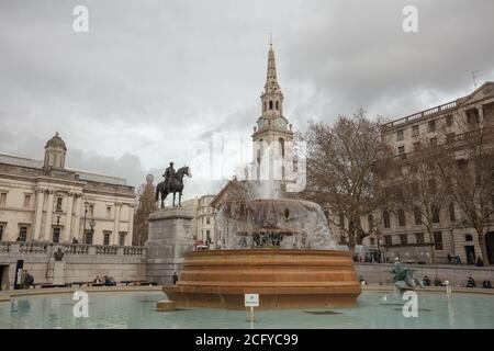 Gros plan sur la grande fontaine de Trafalgar Square avec la statue de George IV, de St Martin in the Fields Church, de la National Gallery London en arrière-plan Banque D'Images