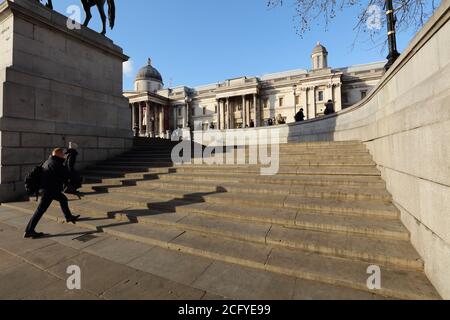 Les gens ont vu marcher sur les marches vers la terrasse nord sur Trafalgar Square Londres vers la National Gallery dans le fond bleu ciel. Banque D'Images