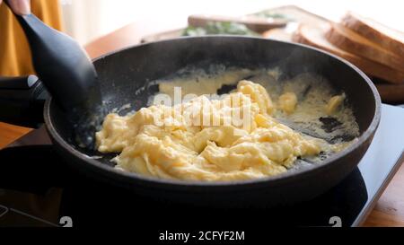 Œufs brouillés dans une casserole. Processus de cuisson des œufs brouillés Banque D'Images