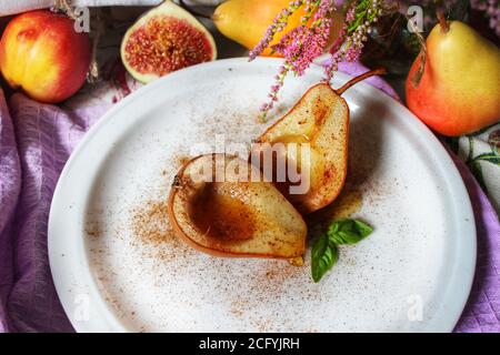 Fruits encore vie poires cuites au sirop sur un blanc Plaque avec une feuille de menthe.texture ou arrière-plan Banque D'Images