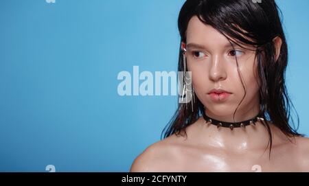 Portrait de belle femme gothique avec piercings et autres accessoires en studio sur fond bue. Émotif, jeune visage. Émotions humaines, exp. Facial Banque D'Images