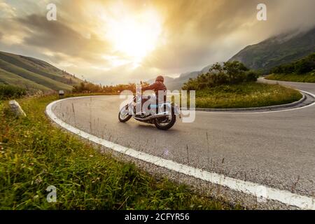 Conducteur de moto dans le paysage alpin. Photo de style de vie avec effet de flou de mouvement. Banque D'Images