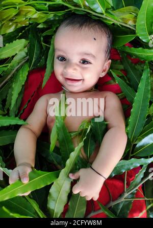 bébé jouant avec des feuilles et montrant son adorable expression faciale gros plan Banque D'Images