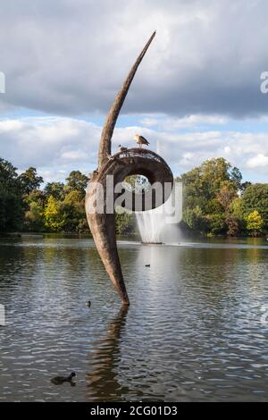 Une fontaine et une sculpture de foin et d'acier dans le lac à Victoria Park, Hackney, Londres par l'artiste, Erno Bartha. Banque D'Images