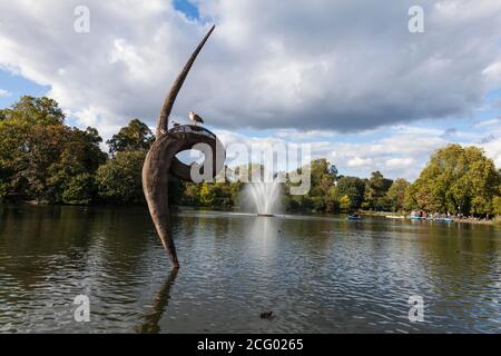 Une fontaine et une sculpture de foin et d'acier dans le lac à Victoria Park, Hackney, Londres par l'artiste, Erno Bartha. Banque D'Images