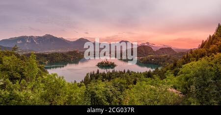 Vue panoramique sur le lac de Bled avec l'île et l'église au coucher du soleil avec les alpes en arrière-plan, Slovénie, Europe Banque D'Images