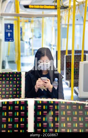 7 septembre, Londres, Royaume-Uni - Femme asiatique assise sur le tube dans une voiture de la Metropolitan Line vide portant un masque facial pendant la pandémie du coronavirus Banque D'Images