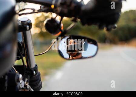 Homme dans le miroir latéral d'une moto Banque D'Images