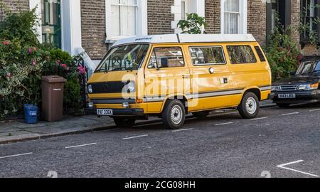 Une fourgonnette VW Camper jaune et blanche garée Une rue à Hackney, Londres, Angleterre, Royaume-Uni Banque D'Images