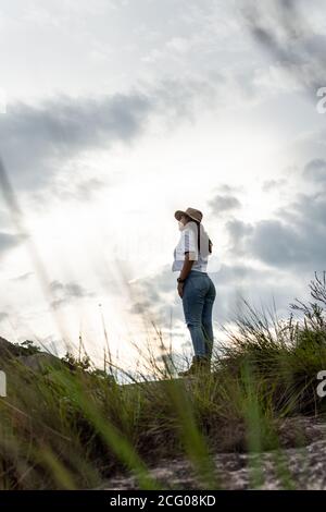 Jeune femme admirant le paysage avec un ciel nuageux dedans arrière-plan Banque D'Images