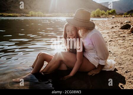 Maman et fille se serrer et passer un moment calme lakeshore Banque D'Images