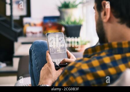 Jeune homme jouant à Sudoku Game avec l'application sur smartphone Banque D'Images