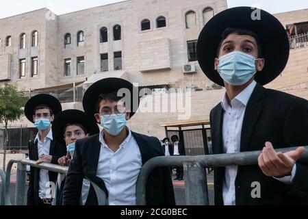 Jérusalem, Israël. 8 septembre 2020. Des hommes juifs ultra orthodoxes attendent à une gare routière pour fuir le quartier de Ramat Shlomo à Jérusalem, quelques minutes avant qu'un couvre-feu de nuit imposé par le gouvernement entre en vigueur sur 8 quartiers de Jérusalem et 40 villes «réd» à travers le pays, considérées comme des points chauds de la COVID-19. Près d'un demi-million de personnes seront limitées par ce couvre-feu tous les soirs de 19:00 à 05:00 le lendemain, interdites aux rassemblements de plus de 10 personnes dans des zones fermées et 20 dans des zones ouvertes, fermeture du système éducatif et des entreprises à partir de 19:00. Israël est le leader mondial du nouveau taux d'infection quotidien Banque D'Images