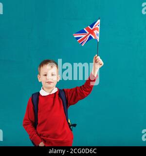 Vacances scolaires Royaume-Uni (Royaume-Uni). Petit écolier avec le drapeau national du Royaume-Uni. Concept scolaire. Rentrée des classes Banque D'Images